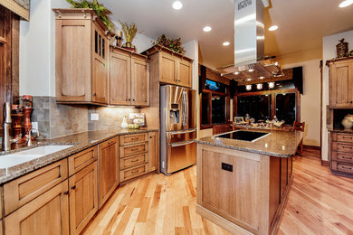 Inspiration for a transitional u-shaped light wood floor eat-in kitchen remodel in Denver with an undermount sink, beaded inset cabinets, beige cabinets, granite countertops, beige backsplash and an island