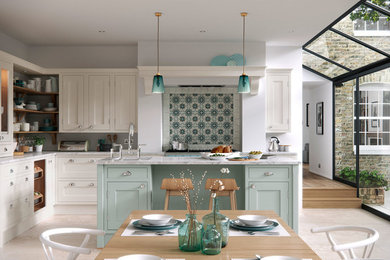 Inspiration for a large country l-shaped open plan kitchen in Manchester with shaker cabinets, marble worktops, an island, blue cabinets and light hardwood flooring.