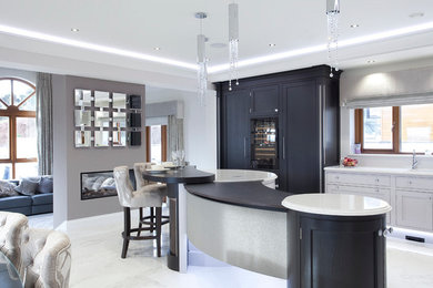 This is an example of a medium sized contemporary l-shaped open plan kitchen in Surrey with an integrated sink, beaded cabinets, grey cabinets, quartz worktops, white splashback, stone slab splashback, stainless steel appliances, marble flooring and an island.
