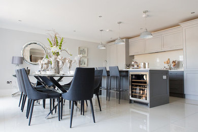 Classic single-wall kitchen/diner in Surrey with an integrated sink, composite countertops, white splashback, integrated appliances, an island and white worktops.