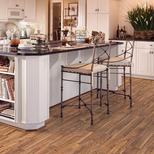 Large country l-shaped kitchen in Indianapolis with a drop-in sink, raised-panel cabinets, white cabinets, white appliances, vinyl floors and with island.