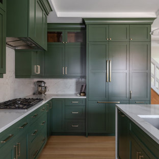 Large transitional eat-in kitchen photos - Inspiration for a large transitional l-shaped light wood floor, brown floor and tray ceiling eat-in kitchen remodel in Detroit with an undermount sink, shaker cabinets, green cabinets, quartz countertops, white backsplash, quartz backsplash, stainless steel appliances, an island and white countertops