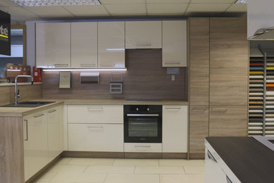 Classic kitchen in Gloucestershire with brown cabinets, granite worktops and beige splashback.