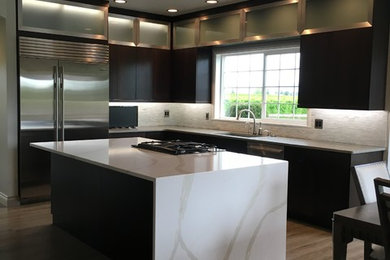 Inspiration for a contemporary kitchen remodel in Seattle with glass-front cabinets, dark wood cabinets, quartzite countertops, white backsplash, stone tile backsplash and an island