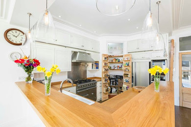 U-shaped kitchen in Hampshire with shaker cabinets, white cabinets and an island.