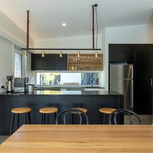Small contemporary galley eat-in kitchen in Canberra - Queanbeyan with a drop-in sink, raised-panel cabinets, black cabinets, quartz benchtops, window splashback, stainless steel appliances, concrete floors, with island, grey floor and black benchtop.