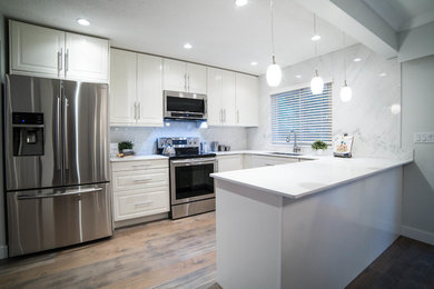 Inspiration for a mid-sized contemporary u-shaped kitchen remodel in Vancouver with white cabinets, quartzite countertops, white backsplash and marble backsplash