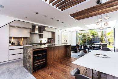 Idéer för ett mellanstort modernt grå kök, med en undermonterad diskho, släta luckor, vita skåp, bänkskiva i kvartsit, stänkskydd med metallisk yta, rostfria vitvaror, klinkergolv i porslin, en köksö och grått golv
