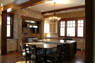 Huge mountain style u-shaped medium tone wood floor open concept kitchen photo in Cedar Rapids with a farmhouse sink, recessed-panel cabinets, white cabinets, granite countertops, beige backsplash, stone tile backsplash, stainless steel appliances and an island