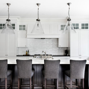 Immagine di una cucina tradizionale con lavello stile country, ante in stile shaker, ante bianche, top in marmo, paraspruzzi bianco, paraspruzzi con piastrelle diamantate, elettrodomestici in acciaio inossidabile, pavimento in legno massello medio e isola