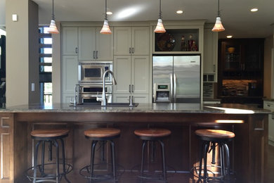 Example of a mid-sized transitional l-shaped light wood floor and gray floor eat-in kitchen design in Other with a double-bowl sink, shaker cabinets, white cabinets, multicolored backsplash, matchstick tile backsplash, stainless steel appliances and an island