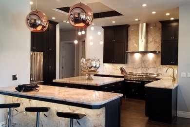 Bild på ett stort funkis kök, med en rustik diskho, skåp i shakerstil, svarta skåp, marmorbänkskiva, grått stänkskydd, stänkskydd i sten, rostfria vitvaror, mörkt trägolv, en köksö och brunt golv