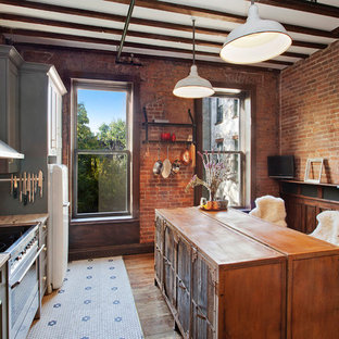 Design ideas for a mid-sized eclectic single-wall kitchen in New York with an undermount sink, shaker cabinets, grey cabinets, granite benchtops, white splashback, subway tile splashback, stainless steel appliances, ceramic floors and with island.