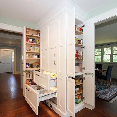 Example of a mid-sized classic dark wood floor eat-in kitchen design in New York with a drop-in sink, beaded inset cabinets, white cabinets, marble countertops, green backsplash, glass tile backsplash, paneled appliances and an island