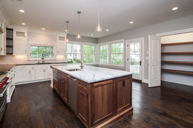Open concept kitchen - large contemporary l-shaped dark wood floor open concept kitchen idea in New York with an undermount sink, shaker cabinets, white cabinets, marble countertops, white backsplash, glass tile backsplash, stainless steel appliances and an island