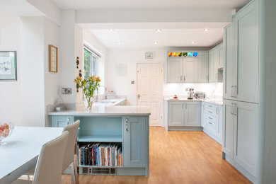 Imagen de cocina comedor actual grande con armarios estilo shaker, puertas de armario azules, encimera de cuarcita, suelo vinílico y encimeras blancas