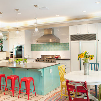 Eat-in kitchen - large modern u-shaped terra-cotta tile and beige floor eat-in kitchen idea in Seattle with white cabinets, stainless steel appliances, a farmhouse sink, raised-panel cabinets, solid surface countertops, white backsplash, subway tile backsplash and an island