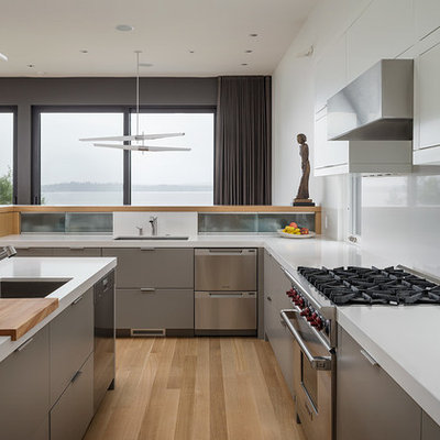 Inspiration for a mid-sized modern u-shaped light wood floor eat-in kitchen remodel in Seattle with an undermount sink, flat-panel cabinets, gray cabinets, stainless steel appliances, quartz countertops, white backsplash and an island