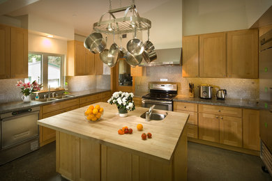 Esempio di una cucina american style di medie dimensioni con lavello a doppia vasca, ante lisce, ante in legno chiaro, top in granito, paraspruzzi grigio, paraspruzzi in lastra di pietra, elettrodomestici in acciaio inossidabile e pavimento in cemento