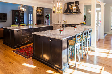 Inspiration for a large transitional galley light wood floor and beige floor open concept kitchen remodel in Baltimore with shaker cabinets, dark wood cabinets, quartzite countertops, white backsplash, ceramic backsplash, stainless steel appliances, two islands, a farmhouse sink and gray countertops