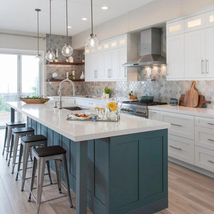 Ispirazione per un grande cucina con isola centrale classico con lavello sottopiano, ante bianche, paraspruzzi grigio, elettrodomestici in acciaio inossidabile, parquet chiaro, pavimento beige, top bianco, top in quarzo composito, paraspruzzi con piastrelle di vetro e ante in stile shaker