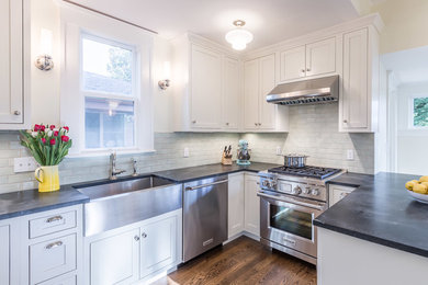 Example of a mid-sized cottage u-shaped medium tone wood floor kitchen design in Seattle with a farmhouse sink and stainless steel appliances