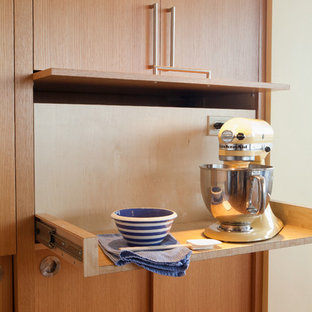 Example of a large mid-century modern galley medium tone wood floor eat-in kitchen design in Seattle with flat-panel cabinets, medium tone wood cabinets, stainless steel appliances and an island