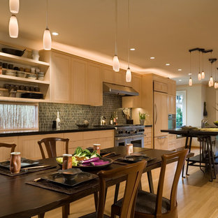Mid-sized transitional galley eat-in kitchen in Seattle with an undermount sink, light wood cabinets, limestone benchtops, panelled appliances, light hardwood floors and with island.