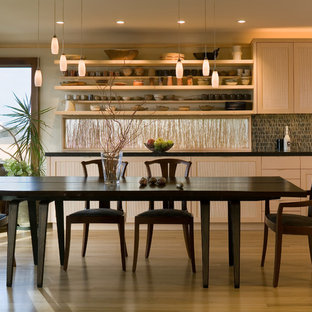 Design ideas for a mid-sized transitional galley eat-in kitchen in Seattle with an undermount sink, light wood cabinets, limestone benchtops, panelled appliances, light hardwood floors and with island.