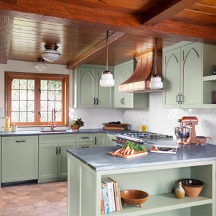Photo of a mid-sized u-shaped kitchen in Seattle with an undermount sink, recessed-panel cabinets, green cabinets, white splashback, a peninsula, brown floor, grey benchtop, exposed beam, wood, marble benchtops and ceramic splashback.