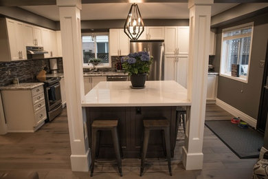 Mid-sized transitional l-shaped dark wood floor and brown floor kitchen photo in Toronto with an undermount sink, stainless steel appliances, an island, shaker cabinets, white cabinets, granite countertops, multicolored backsplash and matchstick tile backsplash
