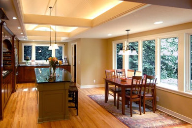 Eat-in kitchen - mid-sized traditional single-wall light wood floor eat-in kitchen idea in Minneapolis with shaker cabinets, medium tone wood cabinets, granite countertops, beige backsplash, ceramic backsplash, stainless steel appliances and an island