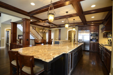 Example of a large classic l-shaped dark wood floor and brown floor eat-in kitchen design in Minneapolis with raised-panel cabinets, brown cabinets, granite countertops, stainless steel appliances and an island