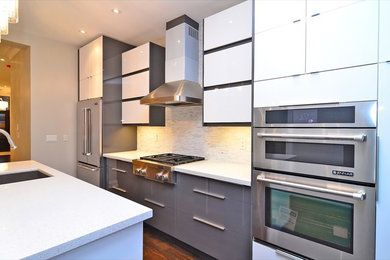 Example of a minimalist single-wall medium tone wood floor kitchen design in Toronto with an undermount sink, flat-panel cabinets, quartz countertops, stainless steel appliances and an island