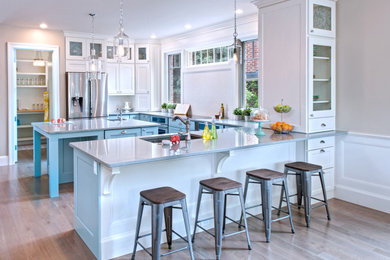 Eat-in kitchen - mid-sized transitional u-shaped light wood floor and gray floor eat-in kitchen idea in Philadelphia with an undermount sink, shaker cabinets, white cabinets, quartz countertops, white backsplash, stainless steel appliances, an island and white countertops