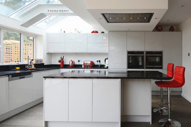 Inspiration for a large modern l-shaped kitchen/diner in Berkshire with white cabinets and an island.