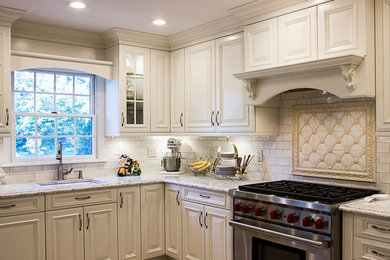 Example of a mid-sized classic u-shaped porcelain tile eat-in kitchen design in New York with an undermount sink, white cabinets, quartz countertops, white backsplash, subway tile backsplash, stainless steel appliances and no island