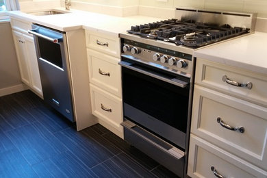 Example of a small transitional galley porcelain tile and black floor eat-in kitchen design in New York with a drop-in sink, beaded inset cabinets, white cabinets, quartzite countertops, white backsplash, mosaic tile backsplash, stainless steel appliances, no island and white countertops
