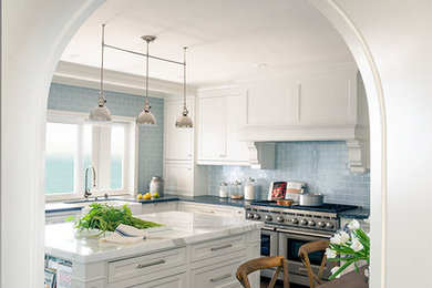 Example of a large beach style u-shaped dark wood floor eat-in kitchen design in Los Angeles with an undermount sink, white cabinets, soapstone countertops, blue backsplash, ceramic backsplash, stainless steel appliances and an island