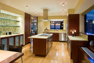 Eat-in kitchen - large contemporary l-shaped light wood floor eat-in kitchen idea in New York with an undermount sink, flat-panel cabinets, dark wood cabinets, solid surface countertops, multicolored backsplash, mosaic tile backsplash, stainless steel appliances and an island