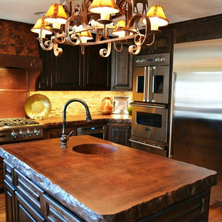 Inspiration for a large country u-shaped eat-in kitchen in Kansas City with a farmhouse sink, shaker cabinets, dark wood cabinets, concrete benchtops, beige splashback, stone tile splashback, stainless steel appliances, medium hardwood floors, multiple islands, brown floor and brown benchtop.