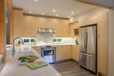 Eat-in kitchen - mid-sized contemporary u-shaped laminate floor and gray floor eat-in kitchen idea in Hawaii with an undermount sink, shaker cabinets, light wood cabinets, quartz countertops, blue backsplash, glass tile backsplash, stainless steel appliances and no island