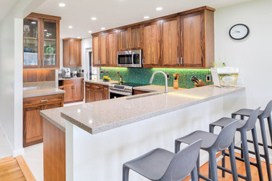 Eat-in kitchen - mid-sized transitional l-shaped porcelain tile eat-in kitchen idea in Hawaii with medium tone wood cabinets, granite countertops, green backsplash, mosaic tile backsplash, stainless steel appliances, no island, an undermount sink and shaker cabinets
