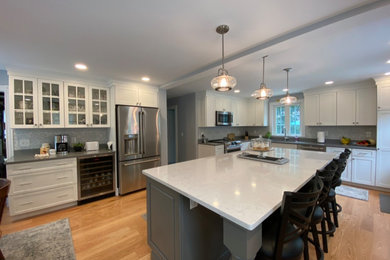 This is an example of a medium sized traditional kitchen/diner in Providence with flat-panel cabinets, engineered stone countertops and an island.