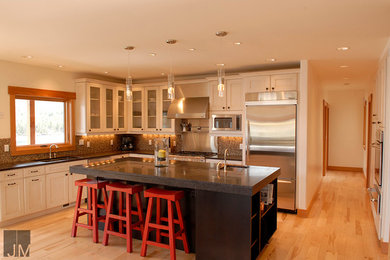 Exempel på ett modernt kök, med skåp i shakerstil, vita skåp, flerfärgad stänkskydd, rostfria vitvaror, ljust trägolv och en köksö