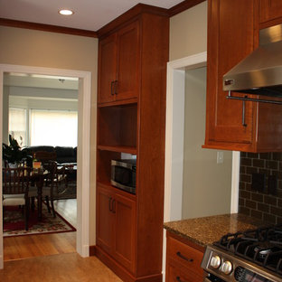 Inspiration for a contemporary separate kitchen in Cedar Rapids with an undermount sink, flat-panel cabinets, medium wood cabinets, recycled glass benchtops, green splashback, glass tile splashback, stainless steel appliances, linoleum floors, no island and yellow floor.