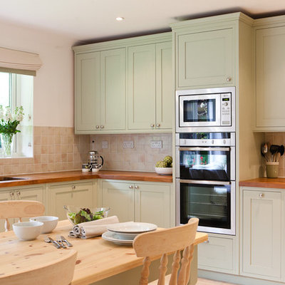 Inspiration for a timeless eat-in kitchen remodel in Berkshire with wood countertops, green cabinets, shaker cabinets, beige backsplash and stainless steel appliances