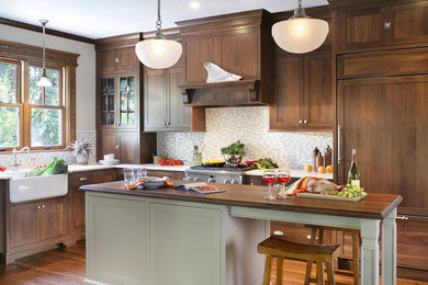 Example of a mountain style kitchen design in Huntington with paneled appliances, a farmhouse sink and wood countertops