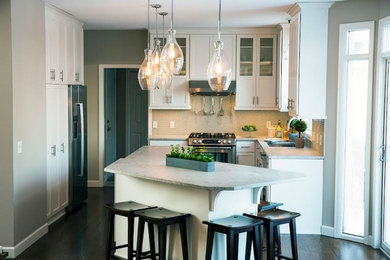This is an example of a large contemporary kitchen/diner in Minneapolis with a built-in sink, glass-front cabinets, white cabinets, granite worktops, glass sheet splashback, stainless steel appliances and dark hardwood flooring.