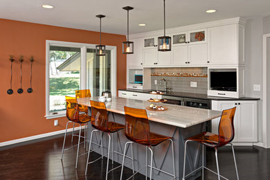 Example of a huge 1950s l-shaped dark wood floor and black floor eat-in kitchen design in Minneapolis with a single-bowl sink, recessed-panel cabinets, white cabinets, quartz countertops, gray backsplash, glass tile backsplash, stainless steel appliances, an island and gray countertops